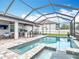 A screened-in pool and spa adjacent to outdoor dining and kitchen areas at 18079 Romanesque Ct, Spring Hill, FL 34610