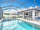 Screened-in pool and spa alongside an outdoor dining area with a bar top, chairs, and television at 18079 Romanesque Ct, Spring Hill, FL 34610