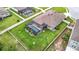 Home's rear view showcases a screened pool, lush lawn, and privacy fence at 18079 Romanesque Ct, Spring Hill, FL 34610