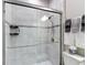 Walk-in shower with glass door, neutral tile, and dual shower heads at 18079 Romanesque Ct, Spring Hill, FL 34610
