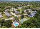 Bird's eye view of neighborhood featuring mature trees, community pool, and a tennis court at 184 Hunter Ct, Palm Harbor, FL 34684