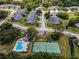 Aerial shot of a neighborhood, showcasing a community pool, tennis court, and well-manicured lawns at 184 Hunter Ct, Palm Harbor, FL 34684