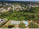 Panoramic aerial shot captures the community tennis courts, pool and surrounding lush greenery at 184 Hunter Ct, Palm Harbor, FL 34684