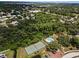 Aerial view of neighborhood featuring a tennis court and community pool nestled in a lush, wooded area at 184 Hunter Ct, Palm Harbor, FL 34684