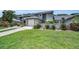 Charming townhome with lush front lawn, flowering shrubs, and an attached single car garage at 184 Hunter Ct, Palm Harbor, FL 34684