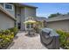 Relaxing outdoor brick patio featuring table, chairs, grill and colorful landscaping at 184 Hunter Ct, Palm Harbor, FL 34684