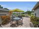 Brick patio with dining table, umbrella, and green shrubbery at 184 Hunter Ct, Palm Harbor, FL 34684