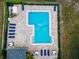 Aerial view of a community pool with a brick paver deck, lounge chairs, and neatly trimmed hedges at 184 Hunter Ct, Palm Harbor, FL 34684