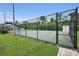 Outdoor tennis court enclosed by a chain-link fence, with lush greenery visible in the background at 184 Hunter Ct, Palm Harbor, FL 34684