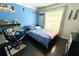 Bright bedroom with a blue accent wall, hardwood floors, and a comfortable bed with lots of natural light from the window at 1842 Ridgelake Ct, Wesley Chapel, FL 33543