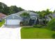 Charming single-story home with a well-manicured lawn, beautiful landscaping, and a brick driveway at 1842 Ridgelake Ct, Wesley Chapel, FL 33543