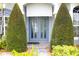 Elegant front door entrance with dual topiary accents and a brick pathway at 1842 Ridgelake Ct, Wesley Chapel, FL 33543