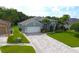 Inviting single-story home featuring a paver driveway, attached garage, and well-maintained landscaping at 1842 Ridgelake Ct, Wesley Chapel, FL 33543