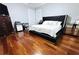 This modern main bedroom has hardwood floors, a large bed, and a dedicated workspace at 1842 Ridgelake Ct, Wesley Chapel, FL 33543
