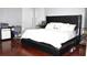 Modern main bedroom with black king bed, shiny floors and workspace near natural light at 1842 Ridgelake Ct, Wesley Chapel, FL 33543