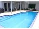 Large screened-in pool with poolside seating and exercise equipment near a covered area at 1842 Ridgelake Ct, Wesley Chapel, FL 33543
