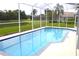 Relaxing screened-in pool offering a serene view of the lush backyard and pond at 1842 Ridgelake Ct, Wesley Chapel, FL 33543