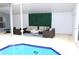 Covered patio with outdoor seating next to a pool and outdoor exercise equipment at 1842 Ridgelake Ct, Wesley Chapel, FL 33543