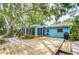 Private backyard featuring a spacious deck, mature trees, and lush tropical landscaping at 2051 Indigo Dr, Clearwater, FL 33763