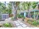 Backyard with a stepping stone path, tropical plants, and a storage shed at 2051 Indigo Dr, Clearwater, FL 33763