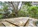 Wooden deck in lush backyard surrounded by mature trees and colorful yard art at 2051 Indigo Dr, Clearwater, FL 33763