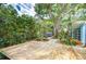 Landscaped backyard featuring a spacious wooden deck, mature trees, and unique art installations at 2051 Indigo Dr, Clearwater, FL 33763
