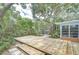Lush backyard with wooden deck, art installations, and mature shade trees at 2051 Indigo Dr, Clearwater, FL 33763