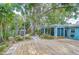 Serene backyard with a wood deck, mature trees, lush landscaping, and storage shed at 2051 Indigo Dr, Clearwater, FL 33763