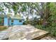 Private backyard featuring a spacious wood deck, BBQ grill, and mature trees at 2051 Indigo Dr, Clearwater, FL 33763