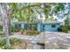 Lush backyard with wood deck, stepping stone path, and tropical landscaping at 2051 Indigo Dr, Clearwater, FL 33763