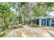 Tranquil backyard with wood deck, mature trees, lush landscaping, and storage shed at 2051 Indigo Dr, Clearwater, FL 33763