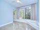 Bright bedroom with large windows, ceiling fan, and polished concrete floors at 2051 Indigo Dr, Clearwater, FL 33763