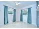 Bedroom featuring two windows with blue curtains, ceiling fan, and built-in shelving at 2051 Indigo Dr, Clearwater, FL 33763