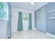 Bedroom featuring a bright window, built-in shelving, and closet with sliding doors at 2051 Indigo Dr, Clearwater, FL 33763