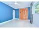 Bedroom featuring a bright blue wall, closet with louvered doors, and ceiling fan at 2051 Indigo Dr, Clearwater, FL 33763