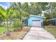 Attractive blue home featuring tropical landscaping, a spacious driveway, and a well-maintained exterior, offering great curb appeal at 2051 Indigo Dr, Clearwater, FL 33763