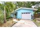 Charming blue home with tropical landscaping, a well-kept driveway, and a welcoming facade for a cozy and inviting feel at 2051 Indigo Dr, Clearwater, FL 33763