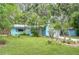 Inviting blue home with tropical landscaping and vibrant greenery, providing a serene and picturesque curb appeal at 2051 Indigo Dr, Clearwater, FL 33763