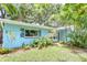 Light blue single-story home featuring tropical landscaping, bright trim, and a well-kept lawn at 2051 Indigo Dr, Clearwater, FL 33763