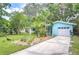 Charming blue home with a white garage door, complemented by lush tropical landscaping and a spacious driveway at 2051 Indigo Dr, Clearwater, FL 33763