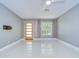 Bright, open living room featuring a modern front door, ceiling fan, and neutral color palette at 2051 Indigo Dr, Clearwater, FL 33763