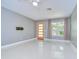 Bright living room featuring polished concrete floors, stylish curtains, and a unique orange glass paneled door at 2051 Indigo Dr, Clearwater, FL 33763