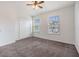 A cozy bedroom featuring neutral carpet, two windows, and a ceiling fan at 2248 Lake Woodberry Cir, Brandon, FL 33510
