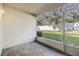 An enclosed patio looking out into the property's backyard, featuring an AC unit and concrete flooring at 2248 Lake Woodberry Cir, Brandon, FL 33510
