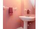 Charming powder room featuring a pedestal sink and pink walls at 2316 Lake Woodberry Cir, Brandon, FL 33510