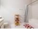 Bright bathroom featuring a tub with a shower and decorative storage for towels and essentials at 2316 Lake Woodberry Cir, Brandon, FL 33510