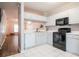 Bright kitchen features white cabinets, black appliances, and white tile flooring at 2316 Lake Woodberry Cir, Brandon, FL 33510