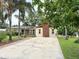 Ranch-style home with well-manicured lawn, red brick details, a long concrete driveway, and mature palm trees at 2523 Krueger Lane, Tampa, FL 33618