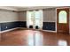 Inviting living room showcasing hardwood floors, picture frame molding, large windows, and wood front door at 2523 Krueger Lane, Tampa, FL 33618