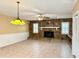 Bright living room featuring a stone fireplace, tile floors, and vintage lighting fixture at 2523 Krueger Lane, Tampa, FL 33618